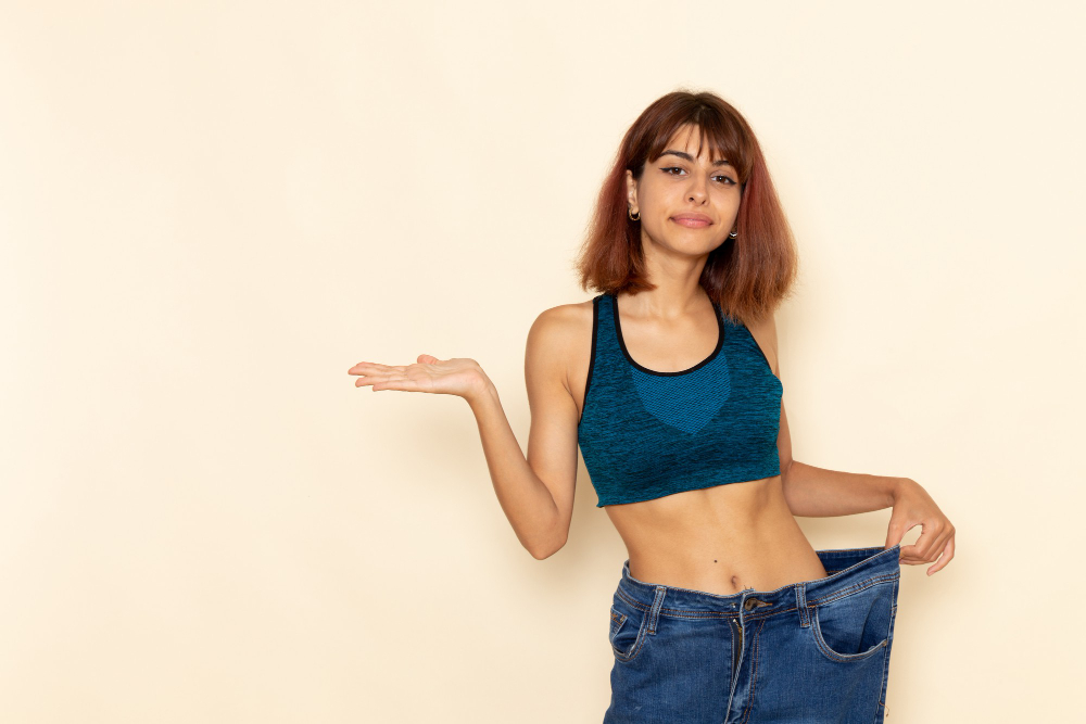 Smiling woman celebrating weight loss success after completing her 12-month Scaled Health and Wellness program.